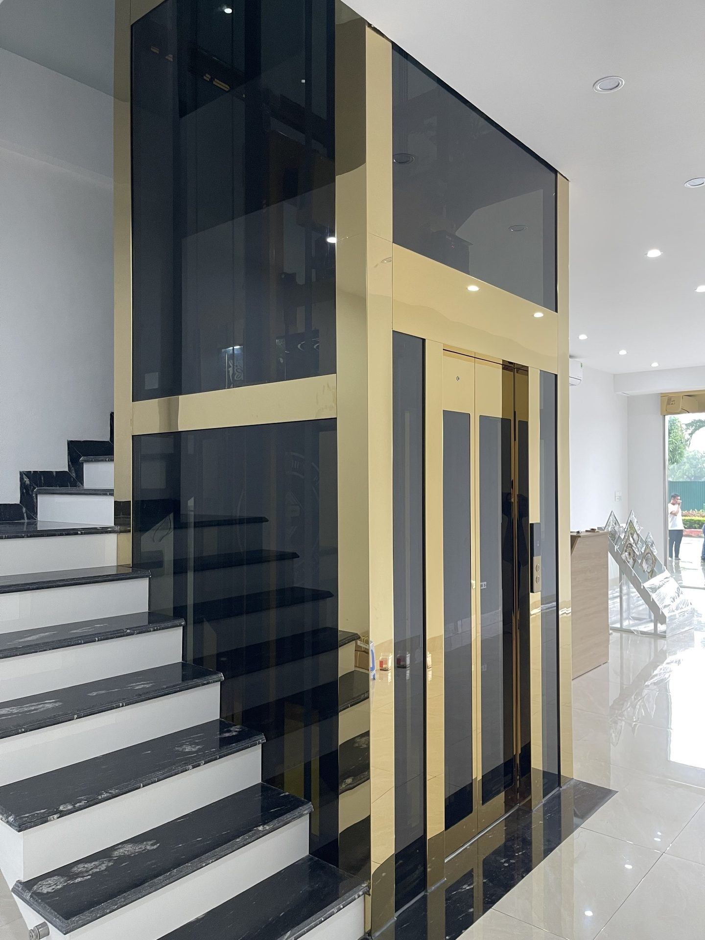 Thang máy trưng bày khung vàng, kính đen tại showroom Hưng Phát, TP Thanh Hóa