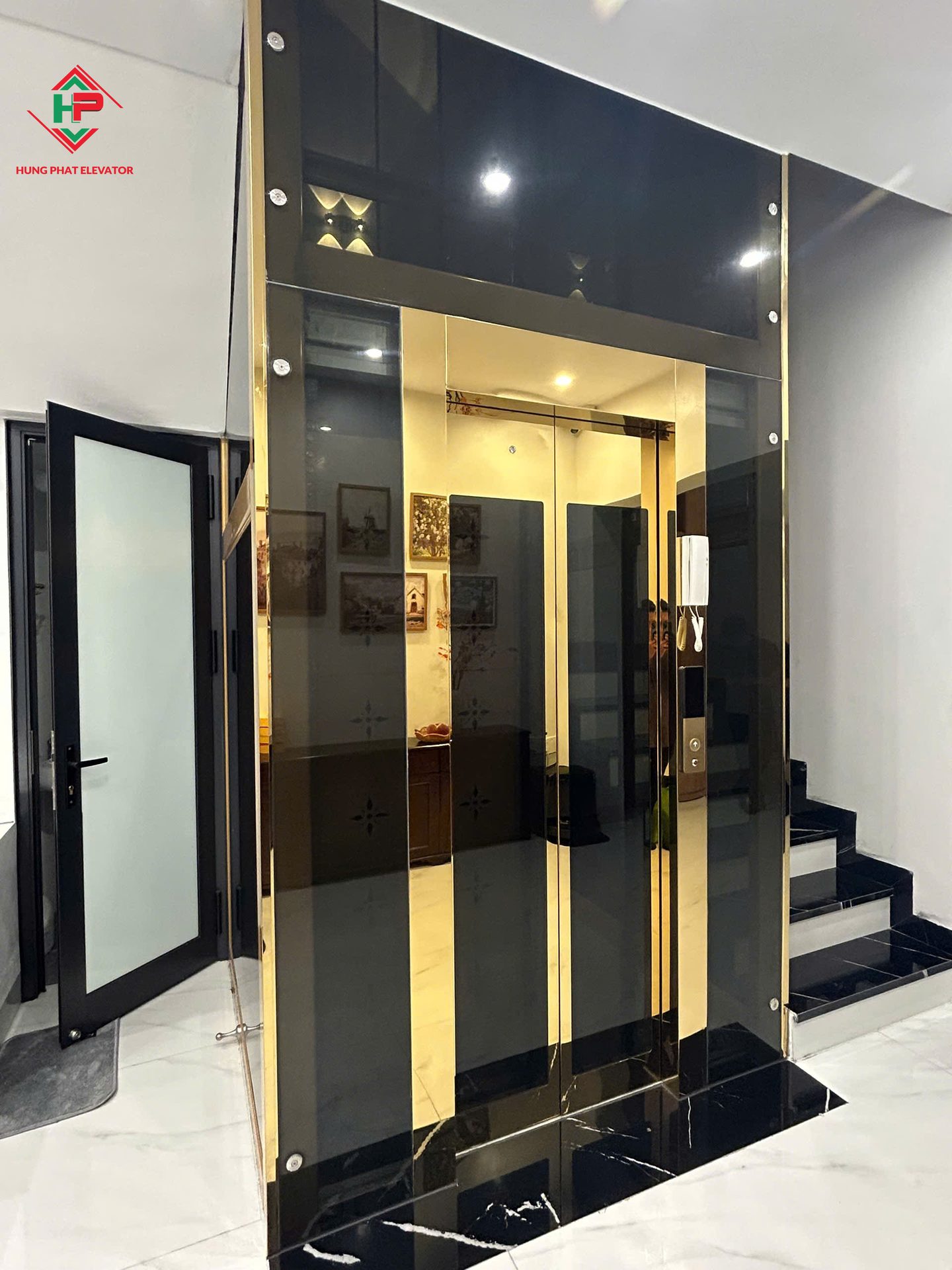 Thang máy kính đen khung vàng trong nhà ở — ảnh 1