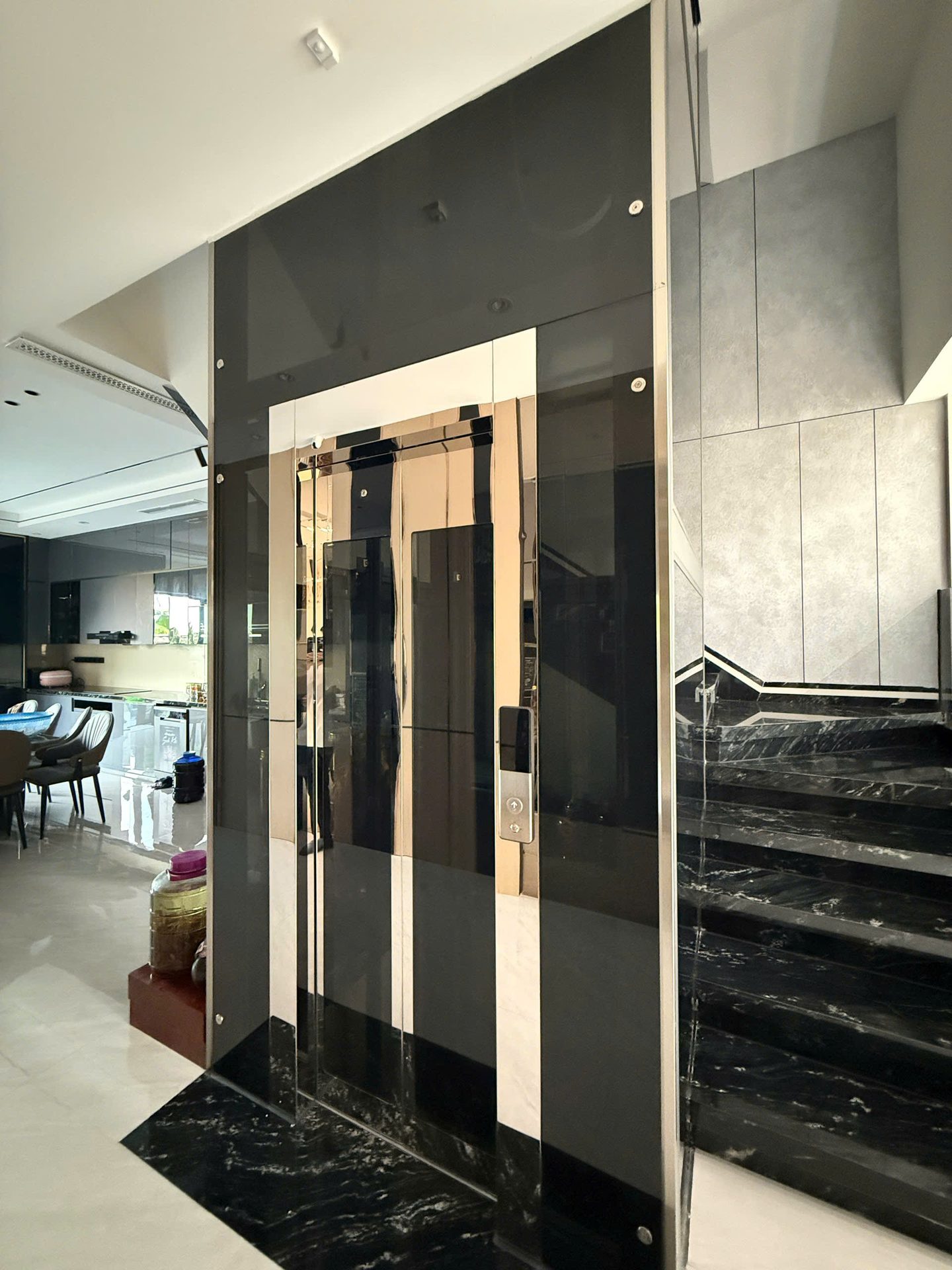 Thang máy kính đen cạnh cầu thang đá trong nhà ở — ảnh 1
